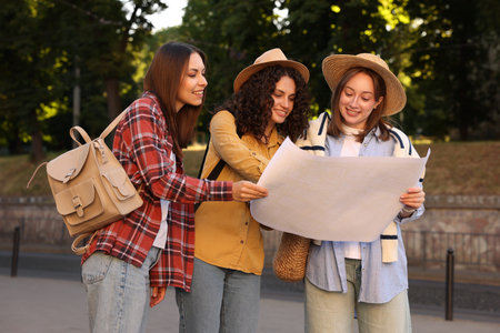 Three tourists with map walking on city streetの写真素材