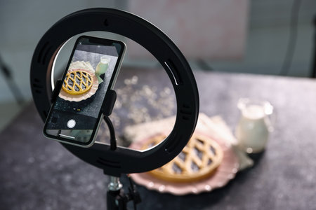 Shooting tasty pie and milk with smartphone in studio, selective focus. Professional food photographyの写真素材
