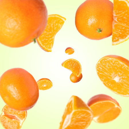 Sweet tangerines whirling in air against beige gradient background