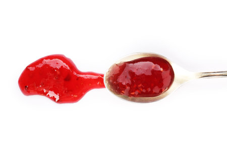 Sweet raspberry jam in spoon isolated on white, top view