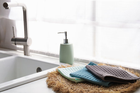 Clean waffle towels on wicker mat near sink, closeupの写真素材