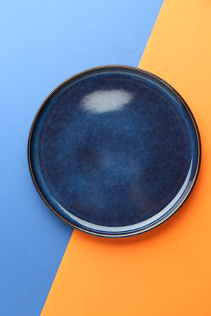 One stylish plate on color background, top viewの写真素材
