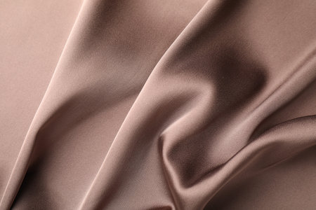Crumpled light brown silk fabric as background, top viewの写真素材