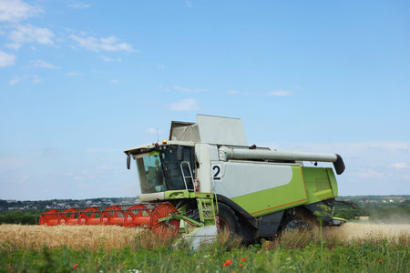 Modern combine harvester working in wheat field