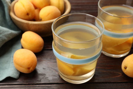 Tasty compot with apricots on wooden table, closeupの写真素材