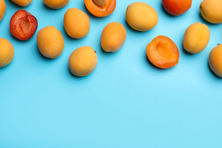 Many fresh apricots on light blue background, flat lay. Space for textの写真素材
