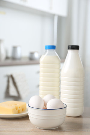 Different dairy products and eggs on wooden table in kitchenの写真素材