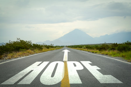 Hope. Word and arrow on asphalt road in countrysideの写真素材