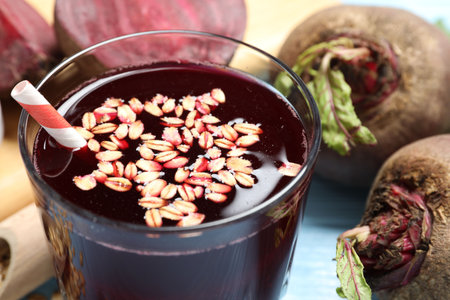 Superfood. Tasty juice with oats in glass and beetroots on light blue table, closeup