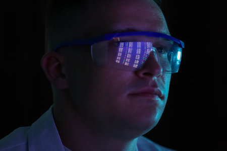 Young man wearing glasses with reflection on dark background, closeup