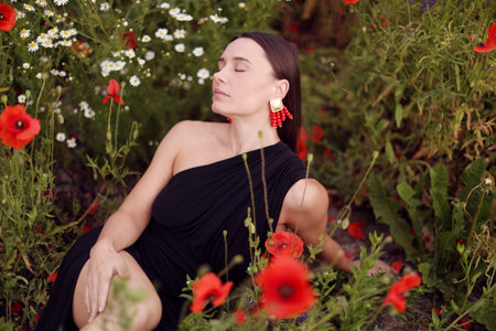 Beautiful woman posing among wildflowers in meadowの写真素材