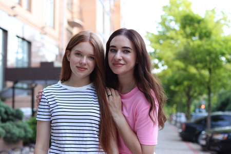 Portrait of beautiful mother and her teenage daughter on city streetの写真素材