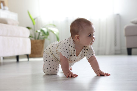 Cute little baby crawling on floor at homeの写真素材