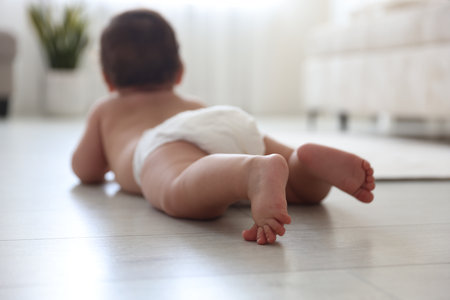 Cute little baby crawling on floor at home, selective focusの写真素材