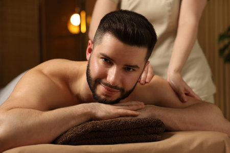 Man receiving relaxing massage in spa salonの写真素材