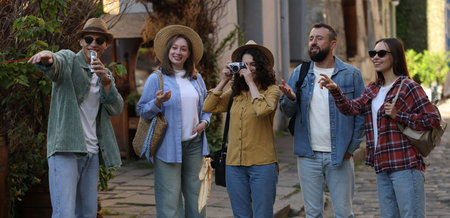 Guide with microphone and group of tourists on city street during excursion