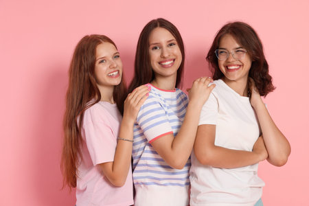 Portrait of happy friends on pink background