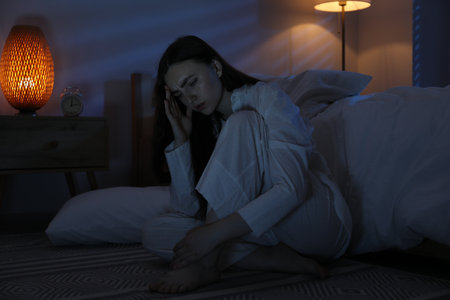 Frustrated woman suffering from insomnia on floor at homeの写真素材