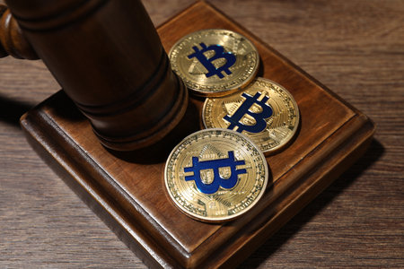 Cryptocurrency. Bitcoins and judge's gavel on wooden table, closeupの写真素材