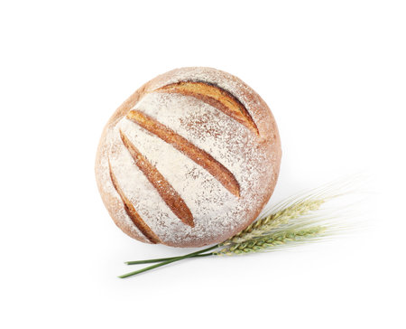 Fresh bread and green wheat spikes isolated on white, top view
