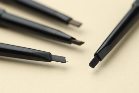 Automatic eyebrow pencils on beige background, macro viewの写真素材