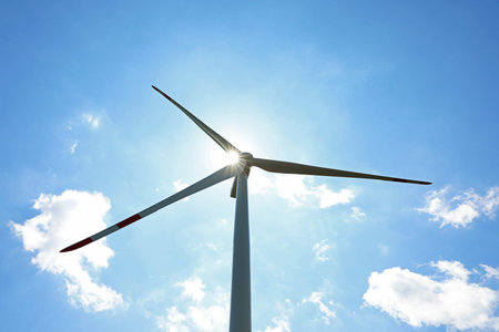 Modern wind turbine against blue sky, low angle view