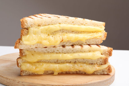 Tasty sandwiches with melted cheese on white table, closeup