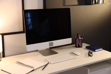 Desk with computer and stationery at home office, closeup. Interior design