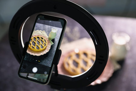 Shooting tasty pie and milk with smartphone in studio, selective focus. Professional food...