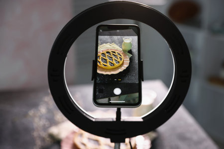 Shooting tasty pie and milk with smartphone in studio, selective focus. Professional food...