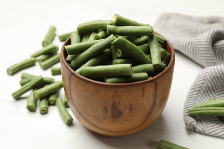 Pieces of fresh pea pods on white table, closeup