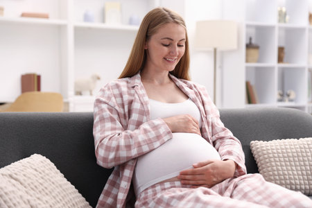 Beautiful pregnant woman on sofa at home