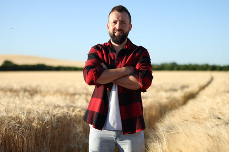 Farmer in field with ripe wheat outdoorsの写真素材