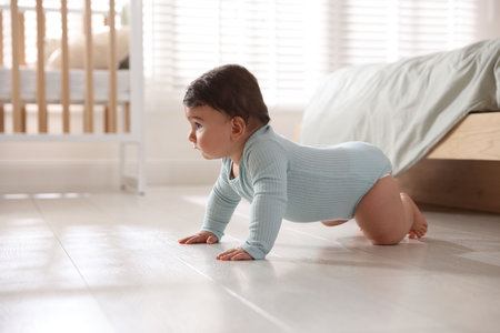 Cute little baby crawling on floor at home, space for text