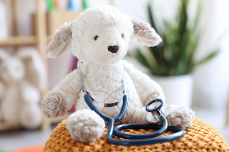 Pediatrician concept. Toy sheep and stethoscope on pouf in clinic, closeupの写真素材