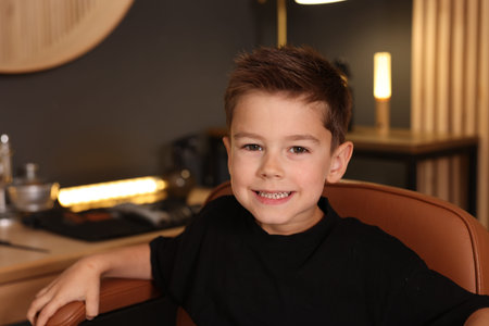 Portrait of cute little boy in barbershopの写真素材