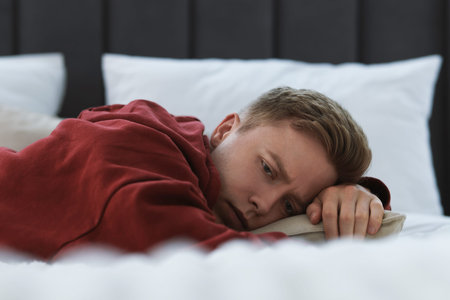 Sad man lying on bed at home. Depression