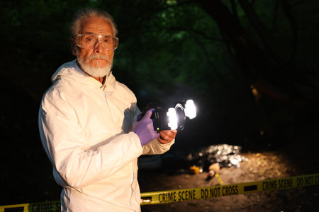 Forensic expert with camera working at crime scene with dead body outdoors, selective focus