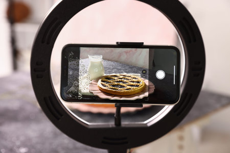 Shooting tasty pie and milk with smartphone in studio, selective focus. Professional food...