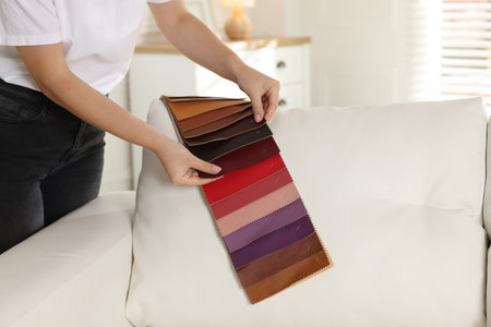Woman choosing fabric among different samples at home, closeup