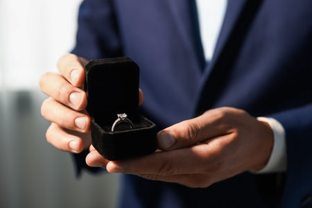 Making proposal. Man with engagement ring indoors, closeup
