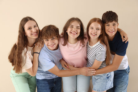Portrait of happy teenage friends on beige background
