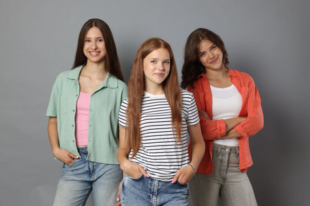 Portrait of happy friends on grey background