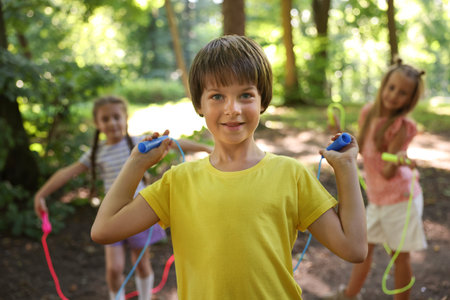 Cute little kids with jump ropes in park, selective focusの写真素材