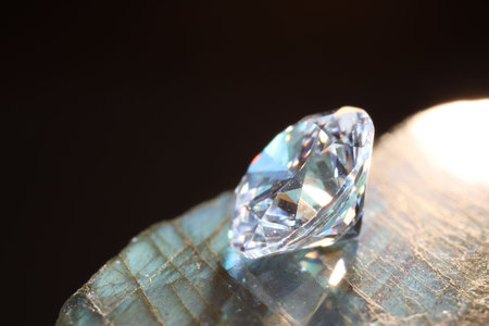 One shiny diamond on stone against black background, macro viewの写真素材