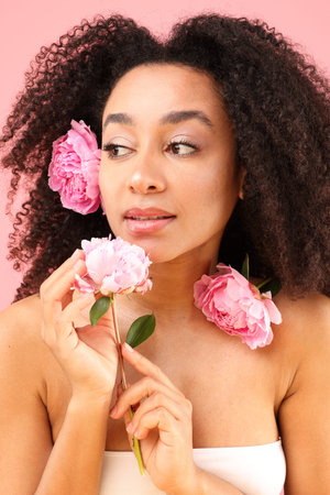 Brazilian woman with peonies on pink background, closeupの写真素材