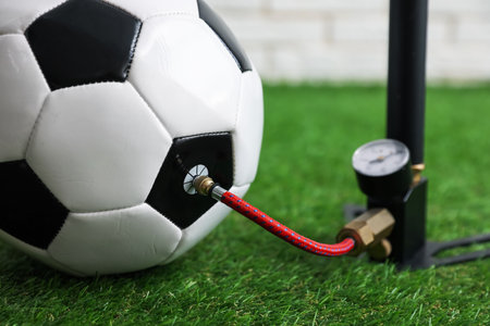 Soccer ball and manual air pump indoors, closeupの写真素材