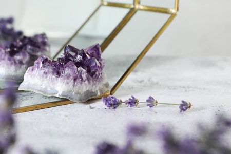 Aura. Beautiful amethyst and lavender on white textured table, closeup