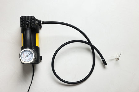 One modern tire inflator on light background, top view