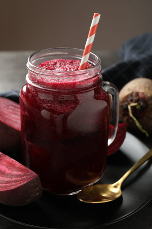 Superfood. Refreshing smoothie in mason jar and beetroots on gray table against brown background,...